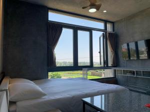 a bedroom with a bed and a large window at miniHomestay green view & warm pool - all apartment - 3 room - 6 persons - Ea Kar - Dak Lak in Buôn Mhang +17 photos