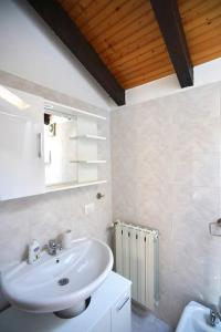 ein weißes Badezimmer mit einem Waschbecken und einem Spiegel in der Unterkunft Comodo Bilocale MXP-RHO/LIUC - Casa Deutzia in Castellanza