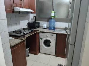 a kitchen with a washing machine and a washer at Lovely 2Bhk Family Apartment in Ajman in Al Ḩamīdīyah
