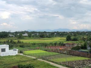 a view of a golf course from behind a fence at miniHomestay green view - 3 room - 1 fan & 1 AC & 1 AC and bathtub - Ea Kar - Dak Lak in Buôn Mhang