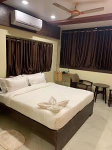 una camera da letto con un grande letto bianco e un ventilatore di Hotel Mohiraj a Bankipur