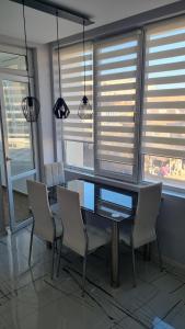 una sala da pranzo con tavolo, sedie e finestre di Alexander Home a Gotse Delchev
