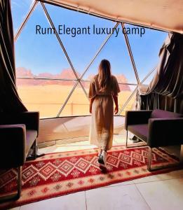 a woman walking in a tent looking out of a window at Rum Elegant luxury camp in Wadi Rum