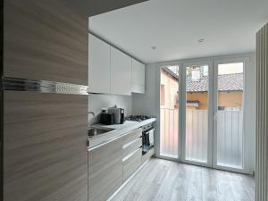 a kitchen with white cabinets and a stove top oven at Ca Belverz center town apartment in Bellagio