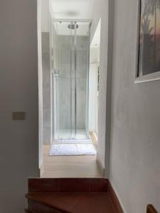 um passadiço com uma cabina de duche em vidro num quarto em Hotel Eden em Follonica