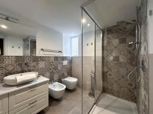 un bagno con doccia, WC e lavandino di Dimora Romantica apartment a Bellagio