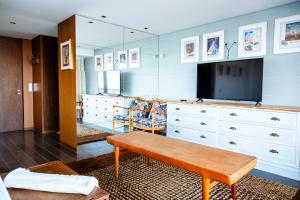 uma sala de estar com uma televisão e uma cómoda em Casa da Barra em Vila Nova de Gaia