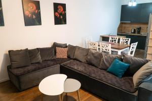 un soggiorno con divano marrone e tavoli bianchi di Signature apartment 5 a Tirana