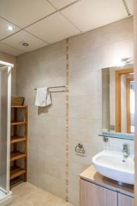 een badkamer met een wastafel en een spiegel bij Llevant 3 in L'Ampolla