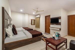 a hotel room with a bed and a tv at Hotel South Indian in New Delhi