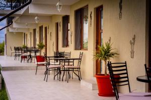 an outdoor patio with tables and chairs and a table at Complex Route 66 in Vama Veche