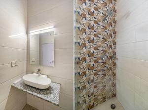 a bathroom with a sink and a mirror at Hotel South Indian in New Delhi