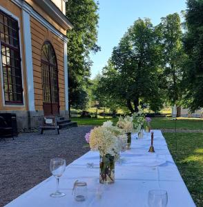 una mesa larga con copas de vino y flores. en Värdshuset & Brukshotellet i Lövstabruk, en Lövstabruk