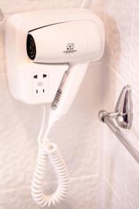 a white phone hanging on a wall in a bathroom at Complex Route 66 in Vama Veche