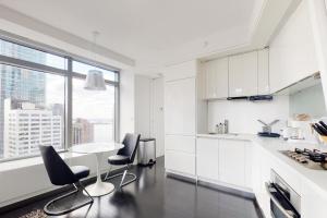 a kitchen with white cabinets and a table and chairs at Blueground Tribeca roof deck nr WTC NYC-1377 in New York