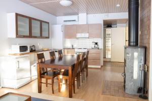 a kitchen with a table and chairs and a stove at Kaisantien Siiri in Kajaani