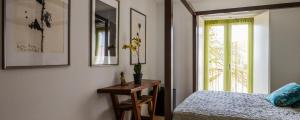 a bedroom with a bed and a table and a window at Tings Lisbon in Lisbon