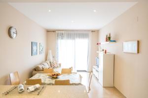 a small living room with a table and a kitchen at Llevant 3 in L'Ampolla