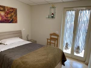 sypialnia z łóżkiem i dużym oknem w obiekcie Appartamento Casa Crispino Mansarda n4 per 3 persone w mieście Frattaminore