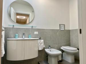 a bathroom with a sink and a toilet and a mirror at Appartamento Casa Crispino Mansarda n4 per 3 persone in Frattaminore