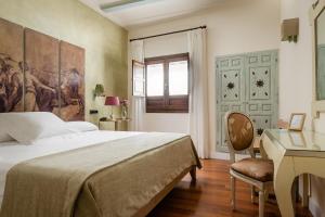 Un dormitorio con una cama y un escritorio y un escritorio. en YIT La Casona del Arco, en Baeza