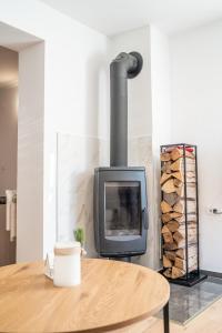 a wood stove in a living room with a table at Apartmaji Ježek Kope in Šmartno pri Slovenj Gradcu