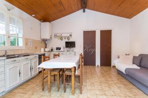 een keuken en een woonkamer met een tafel en een bank bij Petite maison à Biscarrosse - Plage in Biscarrosse