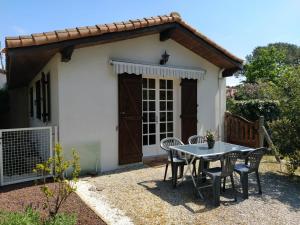 un tavolo e sedie di fronte a una piccola casa di Petite maison à Biscarrosse - Plage a Biscarrosse