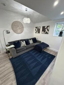uma sala de estar com um sofá e um tapete azul em HOME Hertford em Hertford