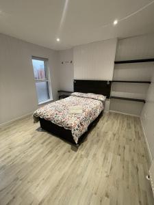 OYO Queens Quarter في بلفاست: غرفة نوم بسرير وارضية خشبية