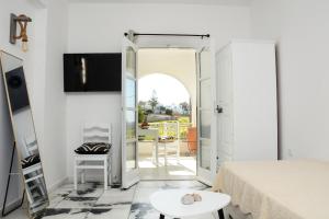a bedroom with a bed and a door leading to a patio at Aegean White Aparts in Naxos Chora