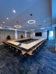 une grande salle de conférence avec une grande table et des chaises dans l'établissement Radsor Hotel, à Râșnov