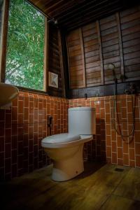 a bathroom with a toilet and a shower at Abing Dalem - Villa Manggis in Tabanan