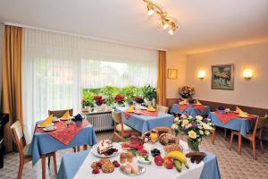 un restaurant avec des tables bleues et de la nourriture sur elles dans l'établissement Hotel Pension Heidi, à Dobel