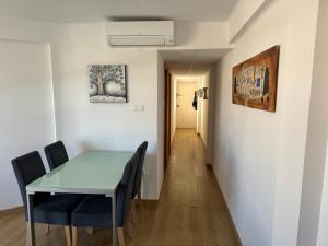ein Esszimmer mit einem Tisch und Stühlen sowie einem Flur in der Unterkunft Acogedor apartamento en Málaga in Málaga