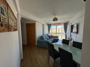 ein Wohnzimmer mit einem blauen Sofa und einem Tisch in der Unterkunft Acogedor apartamento en Málaga in Málaga