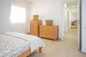a bedroom with a bed and two dressers and a hallway at La Caseta de Sant Pol in Sant Feliu de Guixols +24 photos