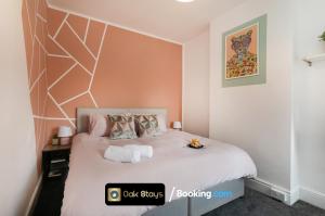 a bedroom with a white bed with a geometric headboard at 87 Allesley Old Road By Oak Stays Short Lets & Serviced Accommodation Leicester Coventry With Free Parking in Coventry