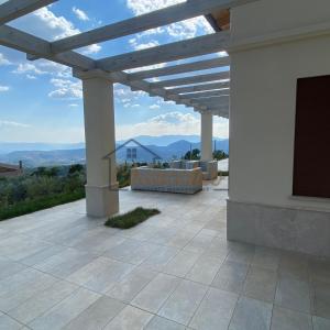 d'une terrasse avec une pergola et des montagnes en arrière-plan. dans l'établissement Villa La Macchia, à Collepardo