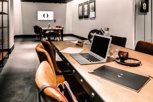 een laptop op een houten tafel met stoelen bij HO Paseo de Almería in Almería