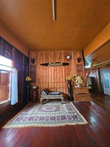 a living room with a couch and a rug at บ้านเรือนไทยมะลิเมืองเก่า in Sukhothai