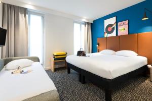 2 Betten in einem Hotelzimmer mit blauen Wänden in der Unterkunft ibis Paris Gare du Nord TGV in Paris