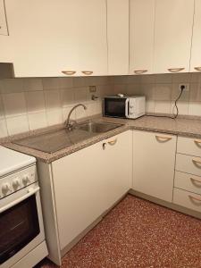 a kitchen with a sink and a microwave at Splendid apartment near beaches and Boccadasse in Genoa