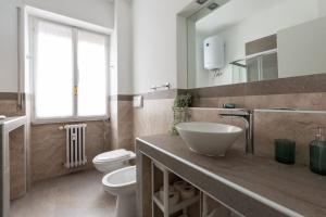 Large Apartment Close to Metro في ميلانو: حمام مع حوض ومرحاض ومرآة