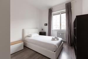Large Apartment Close to Metro في ميلانو: غرفة نوم بيضاء بها سرير ونافذة