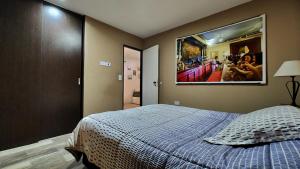 a bedroom with a bed with a picture on the wall at Las margaritas in Uspallata +39 photos