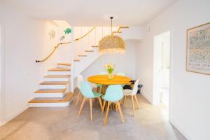a dining room with a table and chairs and a staircase at La Calma in Platja  d'Aro