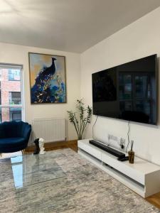 a living room with a tv and a blue chair at Stunning 2-Bed Apartment in Dartford in Dartford