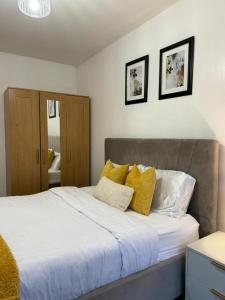 - une chambre avec un grand lit et des oreillers jaunes dans l'établissement Stunning 2-Bed Apartment in Dartford, à Dartford