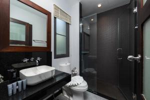 y baño con lavabo, aseo y ducha. en Onyx Villas by TropicLook, en Nai Harn Beach